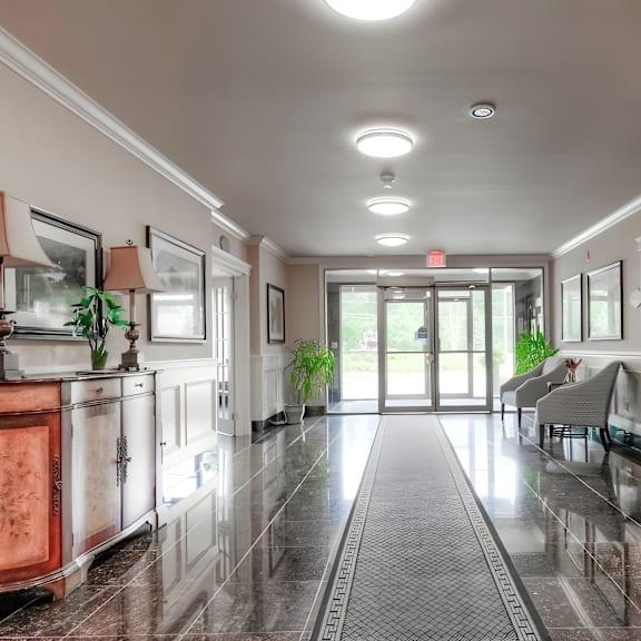 a hallway with a marble floor and a red cabinet.