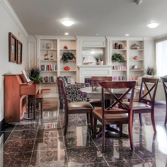 a dining room with a piano and a table set for four.