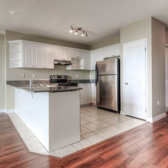 a kitchen with a white island and stainless steel appliances.