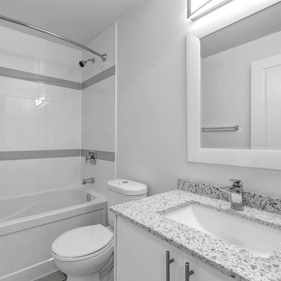 a white bathroom with a toilet, sink, and shower.