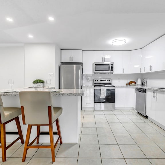 a modern kitchen with white cabinets and appliances.