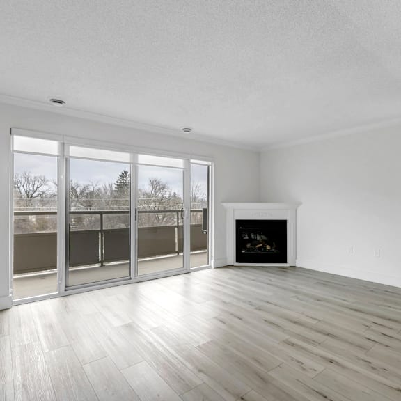 a large, empty room with a fireplace and sliding glass doors.