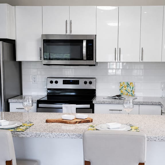 a modern kitchen with a granite countertop and stainless steel appliances.