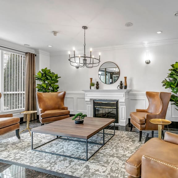 a living room with a fireplace, chairs, and a coffee table.