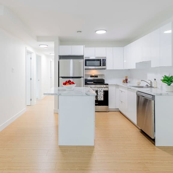 a modern kitchen with white cabinets and stainless steel appliances.