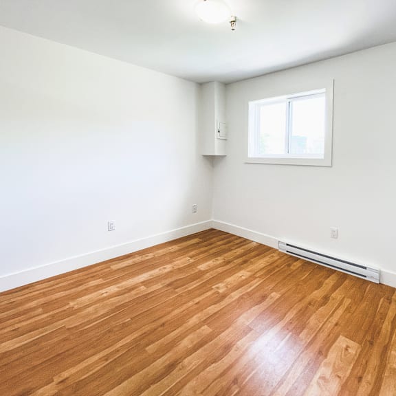 a room with wooden flooring and a window.
