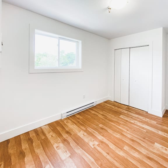 a room with wooden flooring and a window.