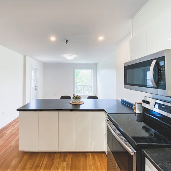 a kitchen with white cabinets and black countertops.