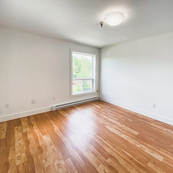 a room with wooden flooring and a window.