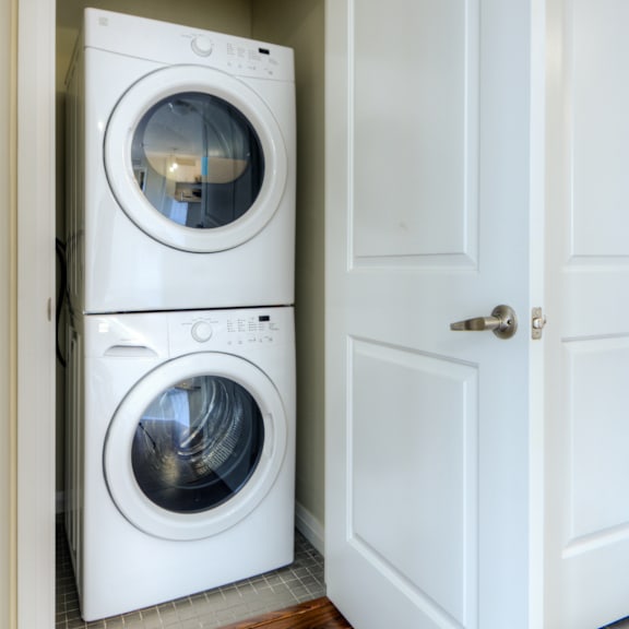 two white front load washing machines in a laundry room.