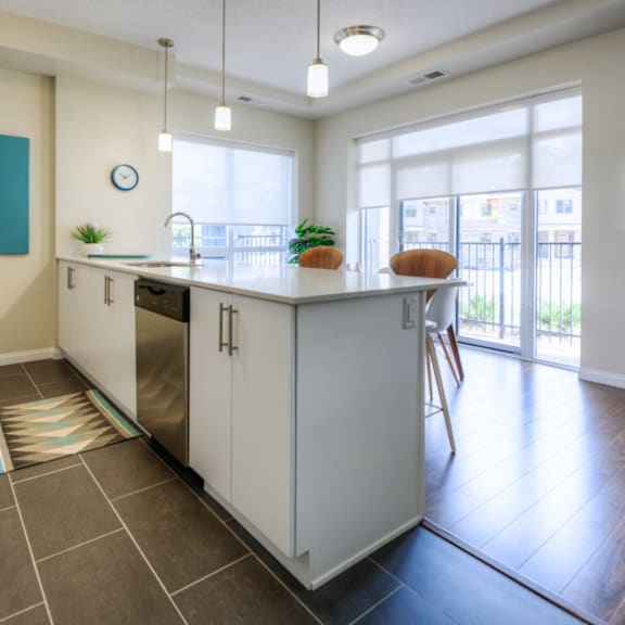 a kitchen with white cabinets and a painting on the wall.