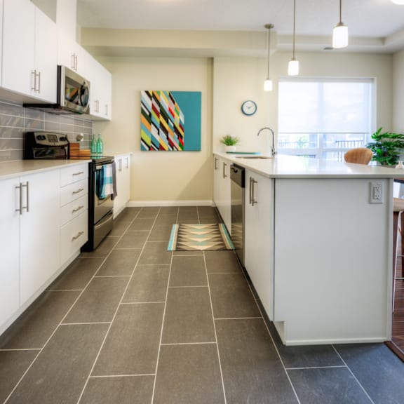 a kitchen with a white island and a painting on the wall.
