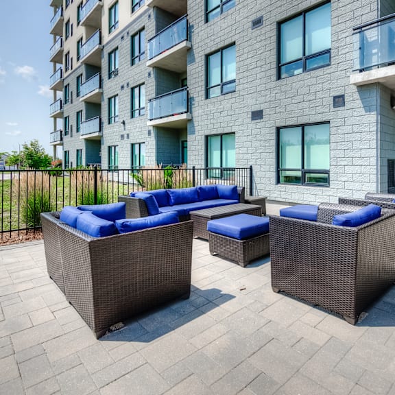a modern building with a patio furniture set in front.