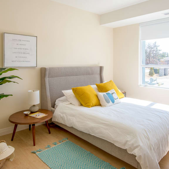 a bedroom with a large bed and a framed quote on the wall.