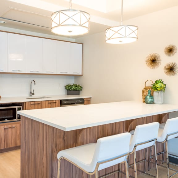 a kitchen with white countertops and wooden cabinets.