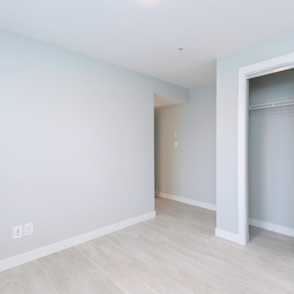 a white door is open in a room with light colored walls and flooring.