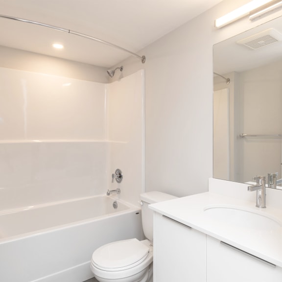 a white bathroom with a toilet, sink, and bathtub.