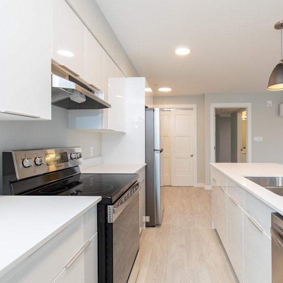 a modern kitchen with white cabinets and stainless steel appliances.