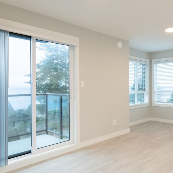a room with a sliding glass door and a window with blinds.