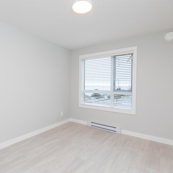 a room with a window and a wooden floor.