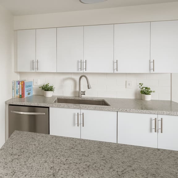 a kitchen with white cabinets and a granite countertop.