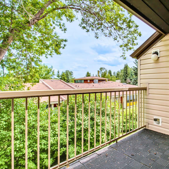 a balcony with a view of a house and trees.