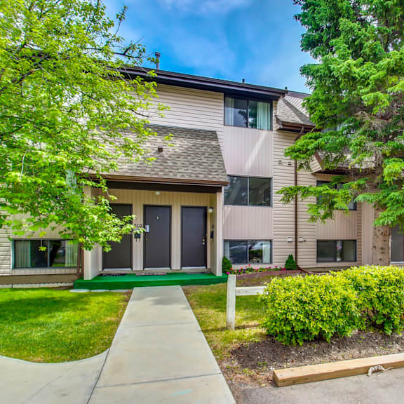 a modern two-story building with a green lawn in front.