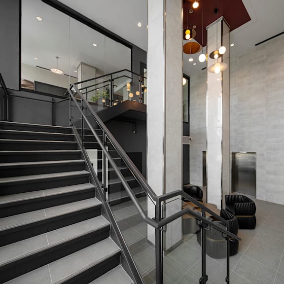a staircase with a metal railing and a black handrail.