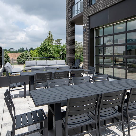 a black table and chairs are set up outside a building.