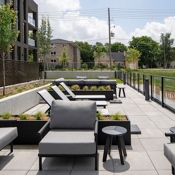 a patio with grey couches and tables.