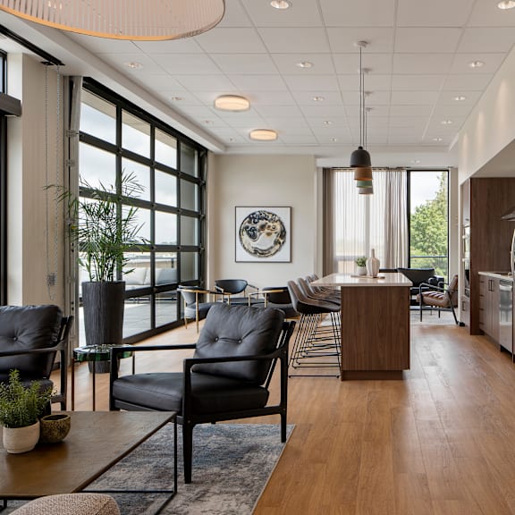 a modern living room with black leather chairs and a wooden coffee table.