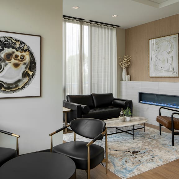 a living room with a black leather couch, a brown leather chair, and a coffee table with a vase of flowers on it.