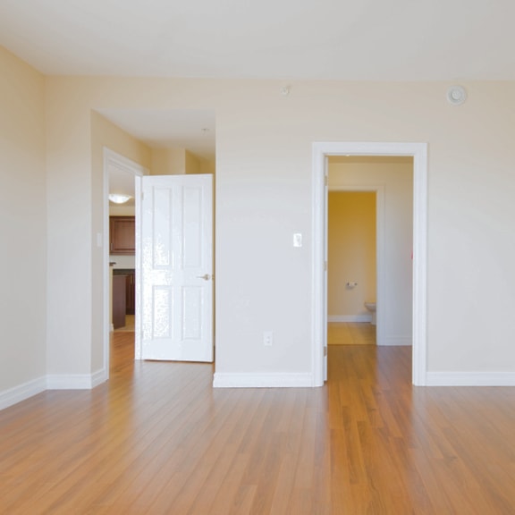 a room with a white door and a wooden floor.