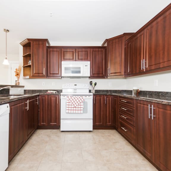 a kitchen with brown cabinets and white appliances.