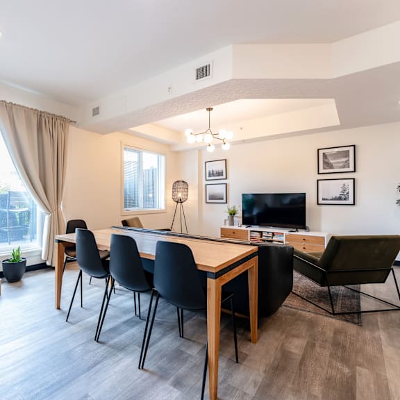 a modern dining room with a wooden table and chairs.