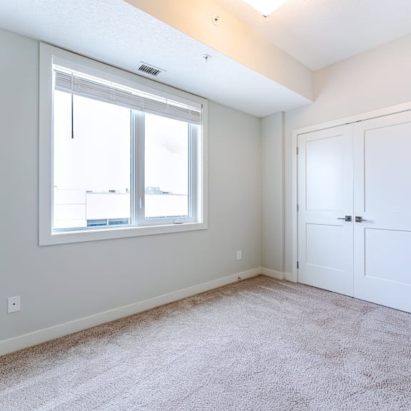a room with a white door and a window with blinds.