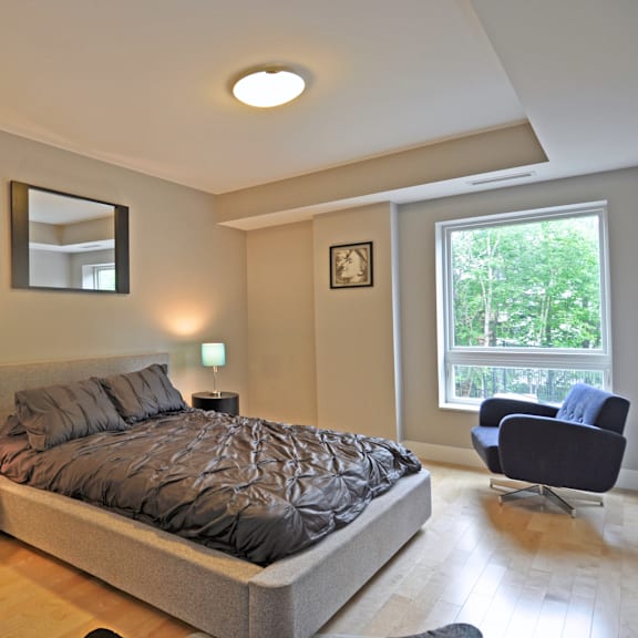 a bedroom with a large bed and a chair.