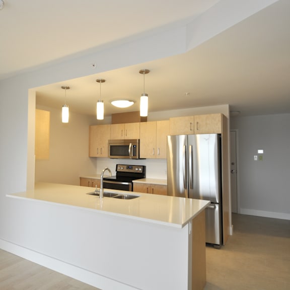 a modern kitchen with a refrigerator, microwave, and oven.