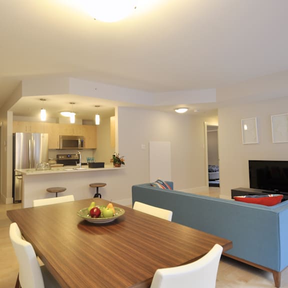 a modern dining room with a wooden table and white chairs.
