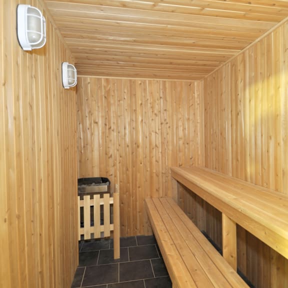 a wooden sauna room with benches and a heater.
