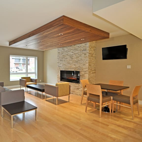 a modern living room with a stone fireplace and a television.