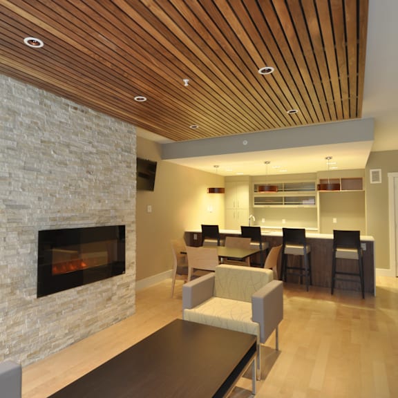 a modern living room with a stone fireplace and wooden ceiling.