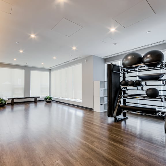 a spacious room with a pilates reformer and a bench.