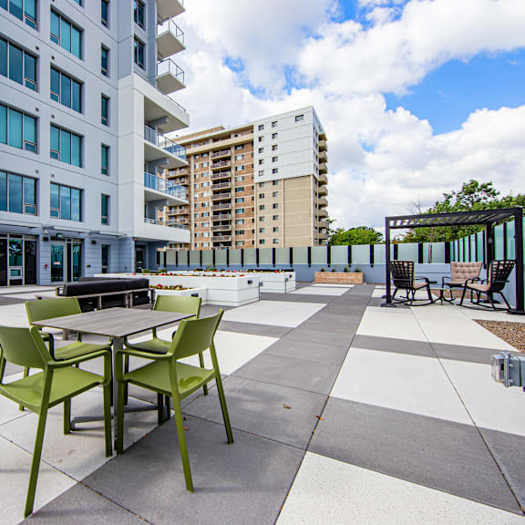 a patio with a table and chairs is in front of a building.