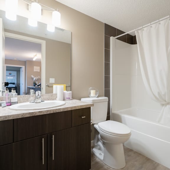 a white toilet sits next to a white sink in a bathroom.