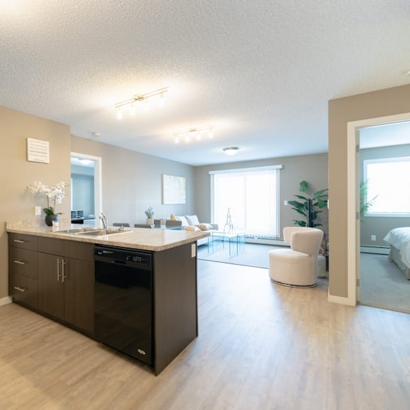 a modern kitchen with dark wood floors and white walls.