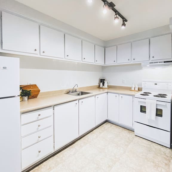 a kitchen with white appliances and cabinets.