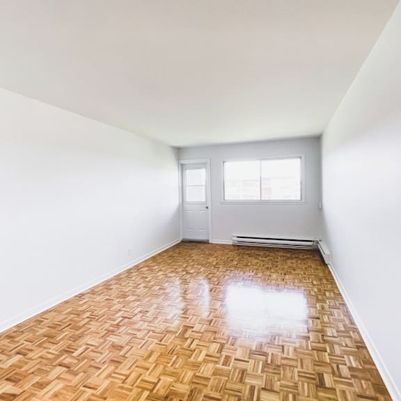 a room with a wooden floor and white walls.