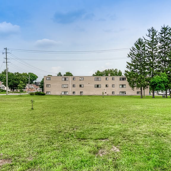 a grassy field with a building in the background.