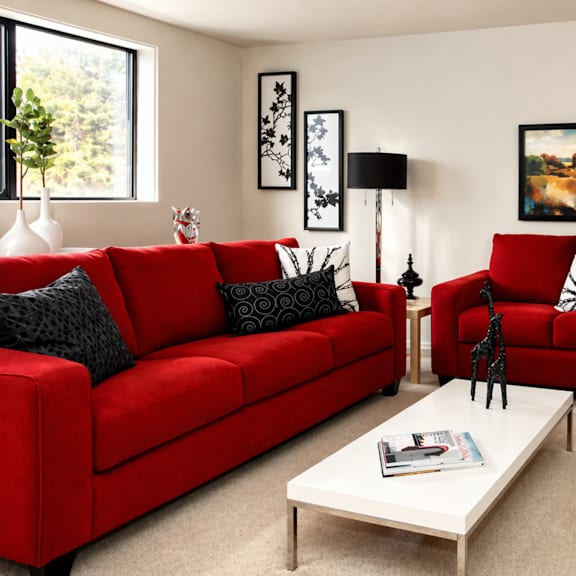 a red couch with a white coffee table in front of it.